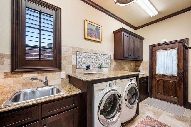Laundry room with cabinet space, independent washer and dryer, and crown molding | Image 14