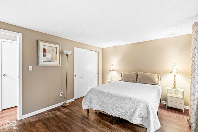 bedroom featuring wood finished floors and a textured ceiling | Image 12