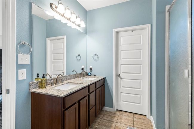 Full bathroom with double vanity, baseboards, and tile patterned flooring | Image 19