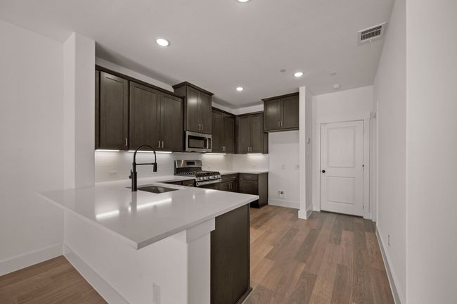 The kitchen peninsula offers a great place for a quick bite or homework station. | Image 7