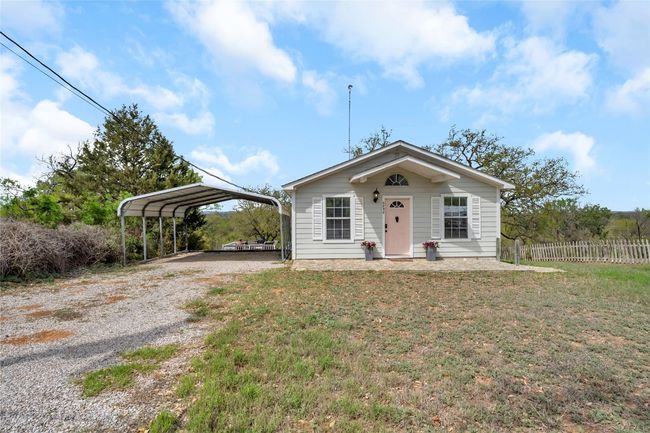 Bungalow-style house featuring driveway, a front yard, fence, and a detached carport | Image 5