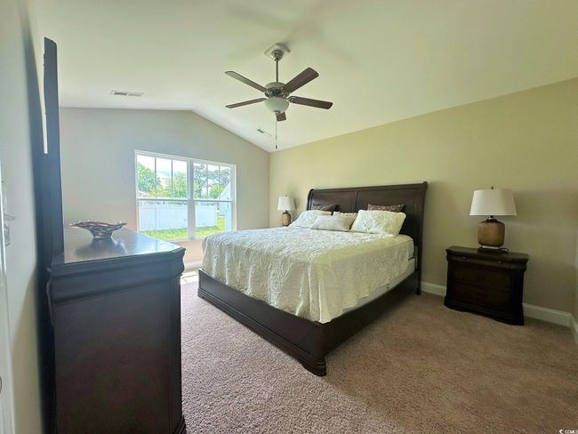 Bedroom featuring lofted ceiling, baseboards, carpet flooring, visible vents, and ceiling fan | Image 7