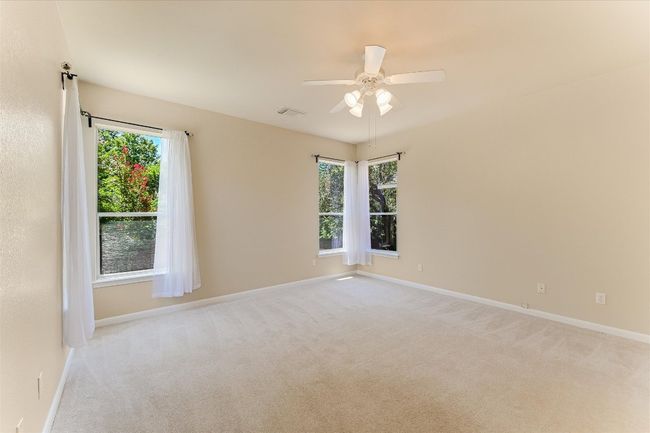 Empty room with light colored carpet and ceiling fan | Image 11