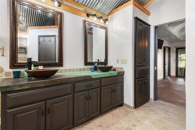 Bathroom with double vanity, a sink, and beam ceiling | Image 16