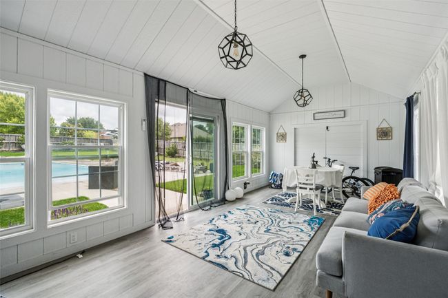 Living area with lofted ceiling, wood finished floors, and wood walls | Image 31