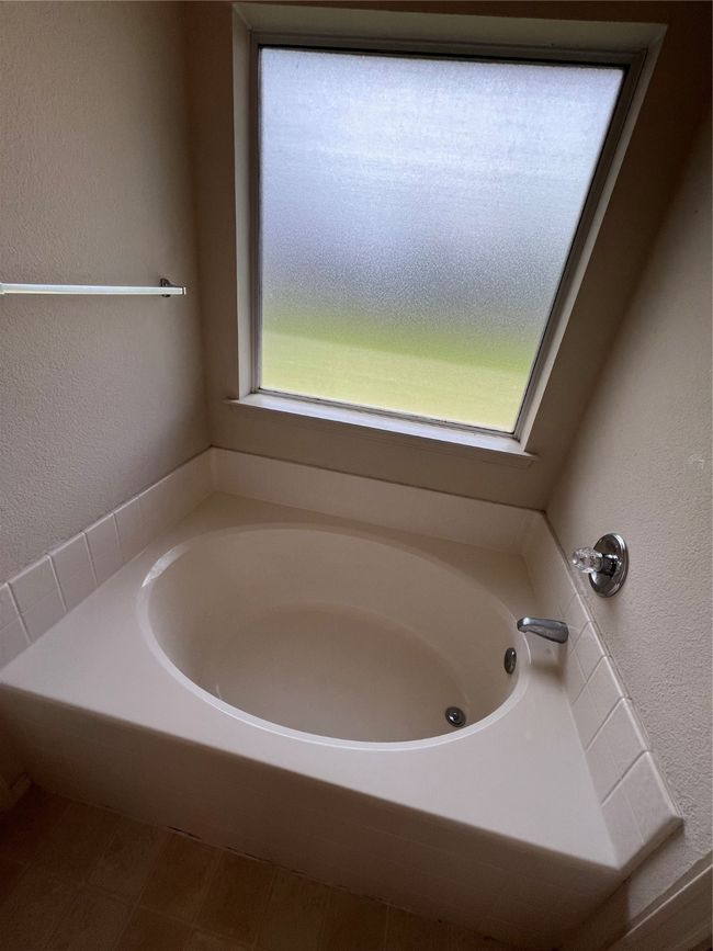 Full bathroom featuring a garden tub and a textured wall | Image 35
