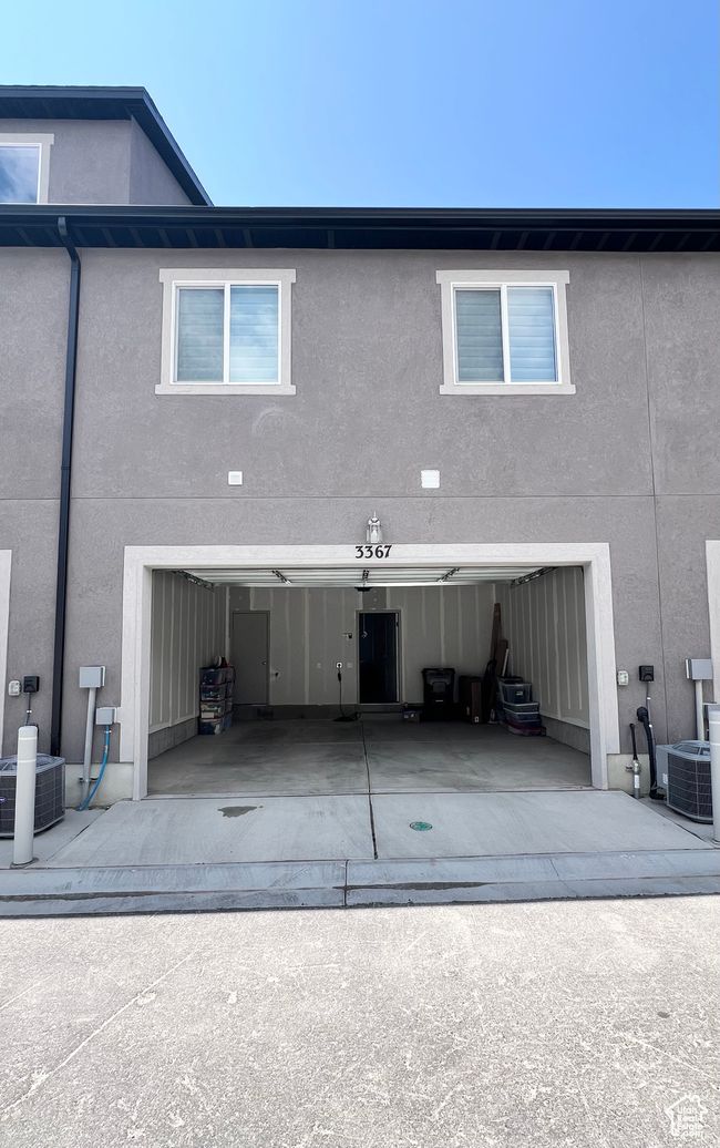Rear view of property with stucco siding, concrete driveway, and a garage | Image 20
