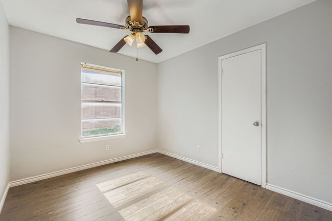 Empty room with wood-type flooring and ceiling fan | Image 9