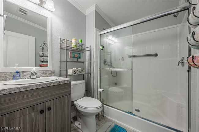 Full bathroom with ornamental molding, a stall shower, toilet, and visible vents | Image 22