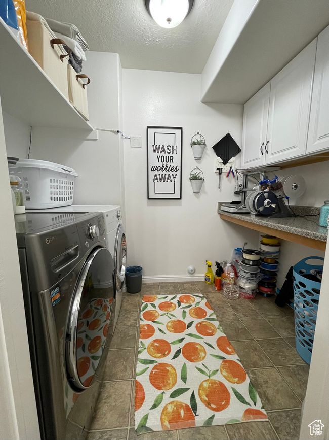 Large laundry area featuring cabinet space, craft or folding shelf | Image 19