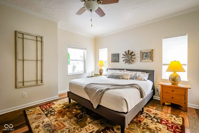 bedroom featuring ornamental molding, wood finished floors, baseboards, and ceiling fan | Image 15