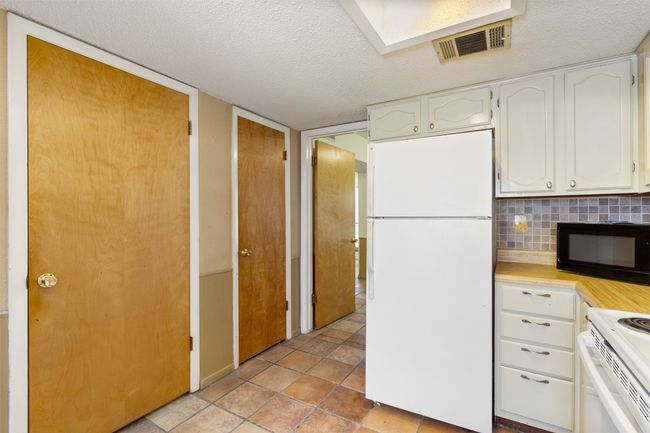Kitchen with cabinets, spacious countertops, and white appliances | Image 6