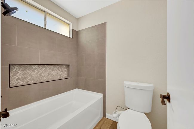 Bathroom with toilet, bathtub / shower combination, and wood finished floors | Image 26