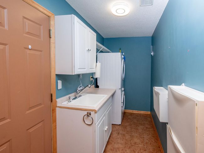 Enjoy the ease of a main-level laundry room complete with a utility sink and ample storage space. | Image 15