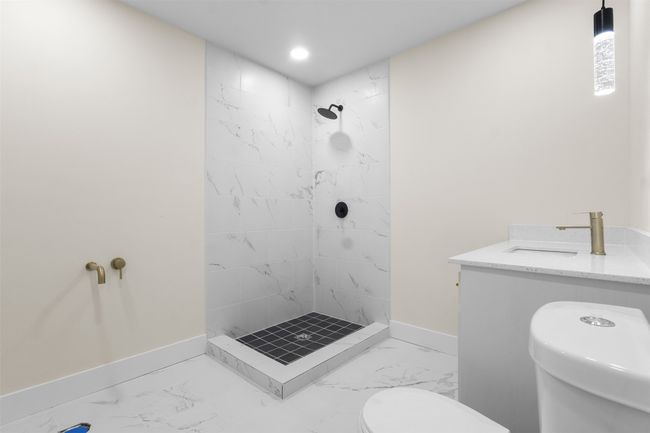 Bathroom featuring marble finish flooring, tiled shower, and recessed lighting | Image 22