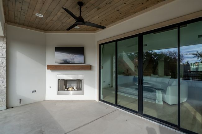 View of patio with a ceiling fan and a fireplace | Image 17