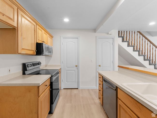 Kitchen featuring stainless steel appliances, light brown cabinetry, light wood-style flooring, light countertops, and recessed lighting | Image 5