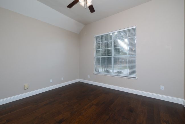 Unfurnished room with a ceiling fan, vaulted ceiling, and dark wood-style flooring | Image 24