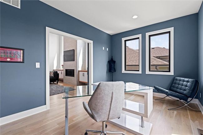 Office space with a fireplace, wood finished floors, and recessed lighting | Image 10
