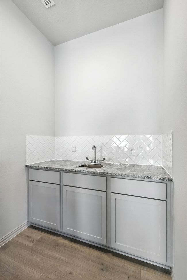 Bar with backsplash and wood finished floors | Image 12