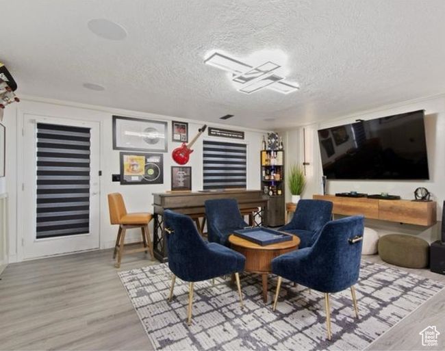 Interior space with a textured ceiling and wood finished floors | Image 20