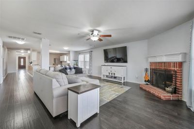 Living room with ceiling fan, dark hardwood / wood-style floors, and a fireplace | Image 2