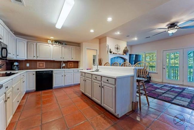 Kitchen offers an island with an extra sink and seating for four. | Image 7
