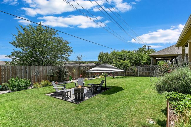 View of yard with a fire pit and a patio area | Image 33