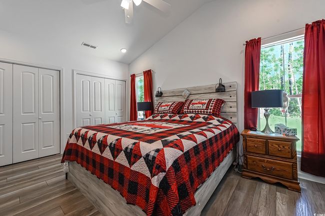 Bedroom featuring lofted ceiling, two closets, wood finished floors, ceiling fan, and recessed lighting | Image 16