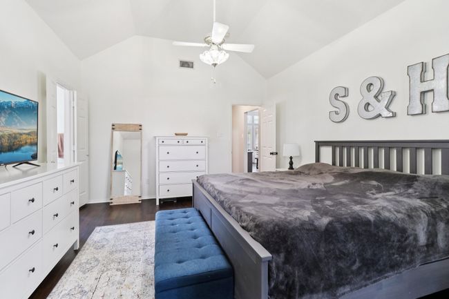 Bedroom featuring dark wood-style floors, a ceiling fan, and high vaulted ceiling | Image 19