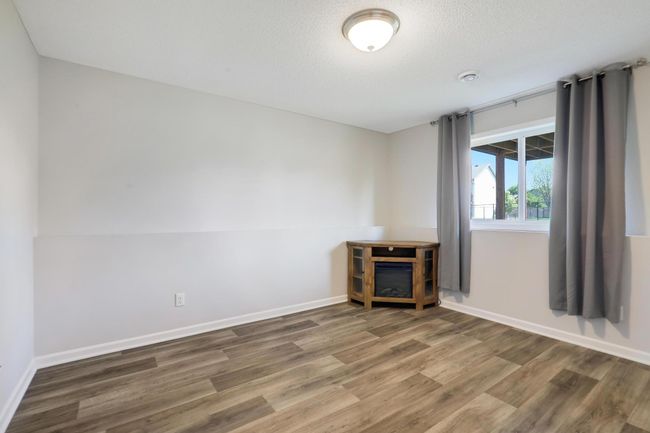 The lower level features a versatile family room, perfect for relaxing or easily converted into a home office to suit your needs. | Image 27