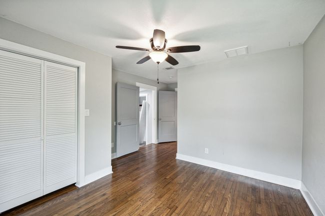 Unfurnished bedroom with dark wood-type flooring, a ceiling fan, and a closet | Image 17