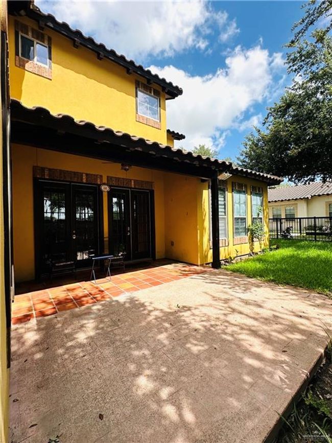 Rear view of property featuring stucco siding, a patio, a tile roof, and french doors | Image 25