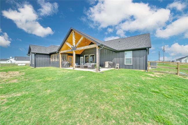 Back of house featuring a yard, an outdoor living space, and a patio | Image 37