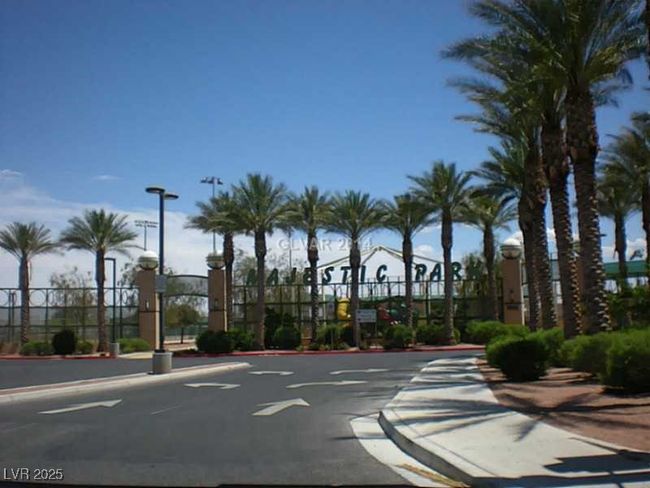 View of asphalt road with curbs, street lights, sidewalks, and a gate | Image 22