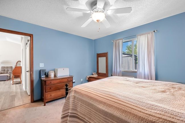 Bedroom featuring a light colored carpet, and a ceiling fan | Image 16