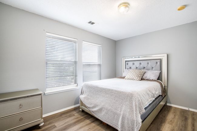 Bedroom with multiple windows and wood finished floors | Image 16