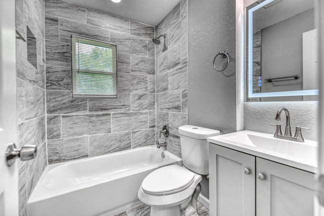Bathroom featuring shower / bathtub combination, vanity, and a textured wall | Image 24
