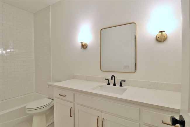 Bathroom featuring toilet, vanity, and shower combination | Image 16