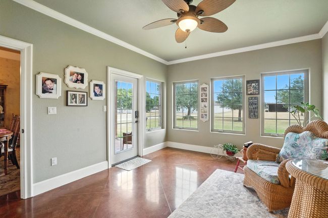 Living area with a ceiling fan and crown molding | Image 19