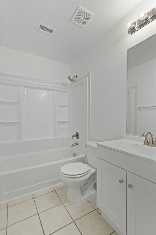 Bathroom featuring vanity, bathtub / shower combination, and tile patterned flooring | Image 22