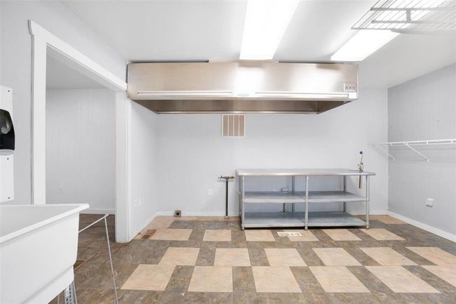 Kitchen space with natural gas hook ups, large commercial grade vent hood, and wash basin | Image 10