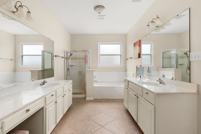 Full bathroom with tile patterned flooring, a sink, a stall shower, and two vanities | Image 18