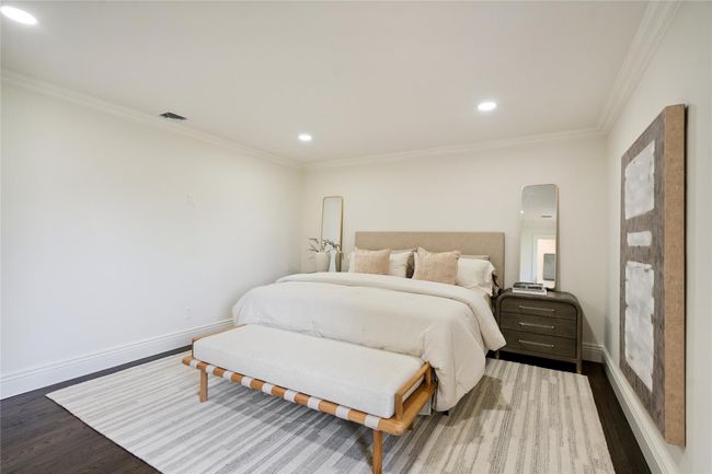 Bedroom featuring wood finished floors, recessed lighting, crown molding, and arched walkways | Image 21