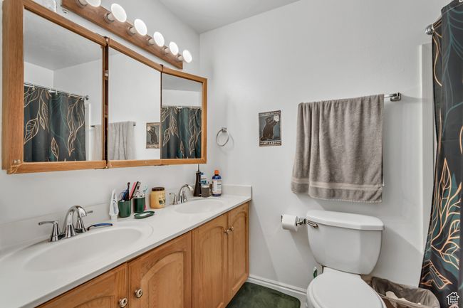 Bathroom featuring double vanity and a shower with curtain | Image 12