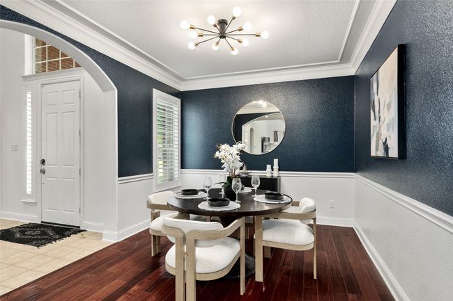 Dining space with a chandelier, arched walkways, ornamental molding, and wood finished floors | Image 7
