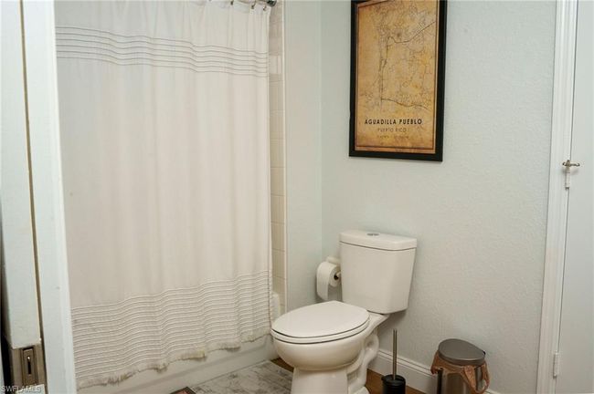Full bathroom featuring toilet, baseboards, and shower / tub combo with curtain | Image 17