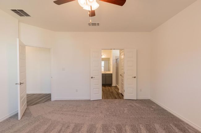 Unfurnished bedroom with ensuite bathroom, visible vents, baseboards, and carpet floors | Image 19