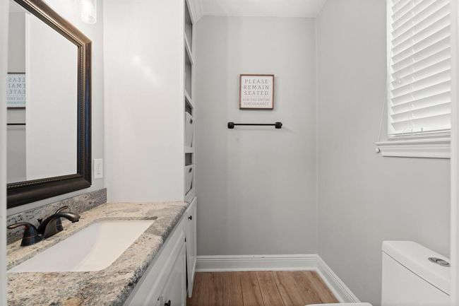 This bathroom includes built-in shelving for storage and a window for natural light. | Image 17