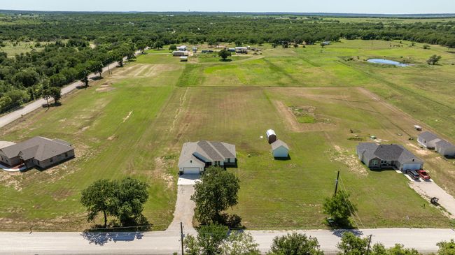 Aerial view of sparsely populated area featuring a large body of water and a heavily wooded area | Image 36